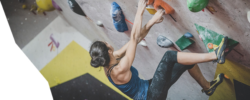grimpeuse dans une salle d'escalade en valais lors d'un cours de coaching donn&eacute; par lionel bonvin