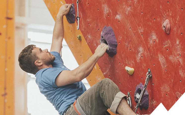 grimpeuse dans une salle d'escalade en valais lors d'un cours de coaching donn&eacute; par lionel bonvin
